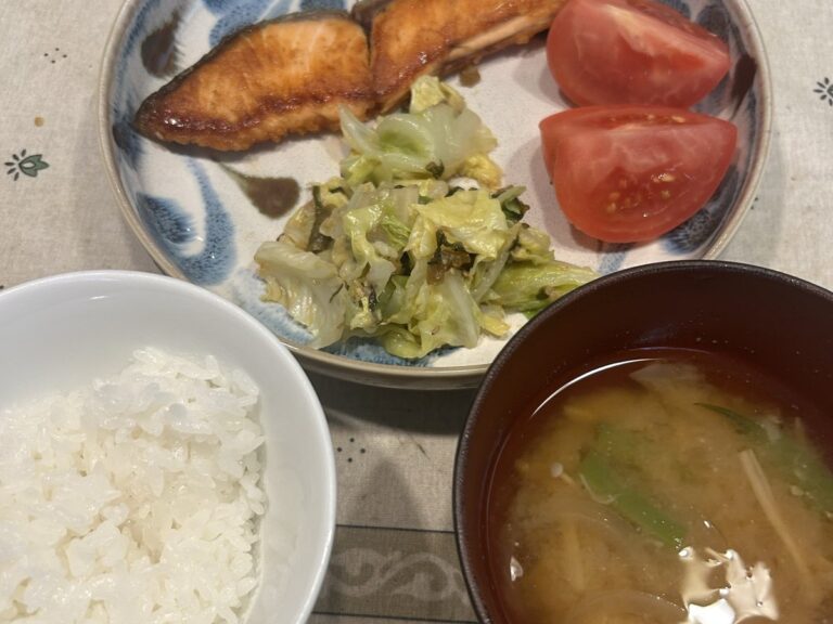 ちあきの家の食卓。焼き鮭とトマト、キャベツのおひたし、ごはん、みそ汁